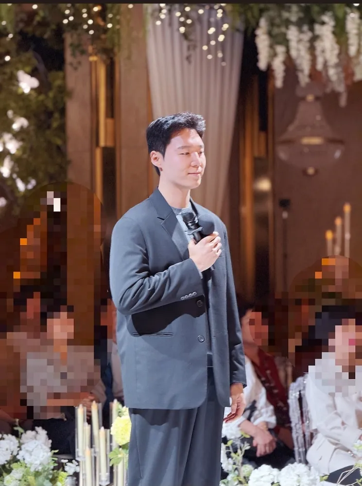 회색 정장 차림으로 마이크를 잡고 결혼식 축가를 부르는 남자 축가 보컬 오창현