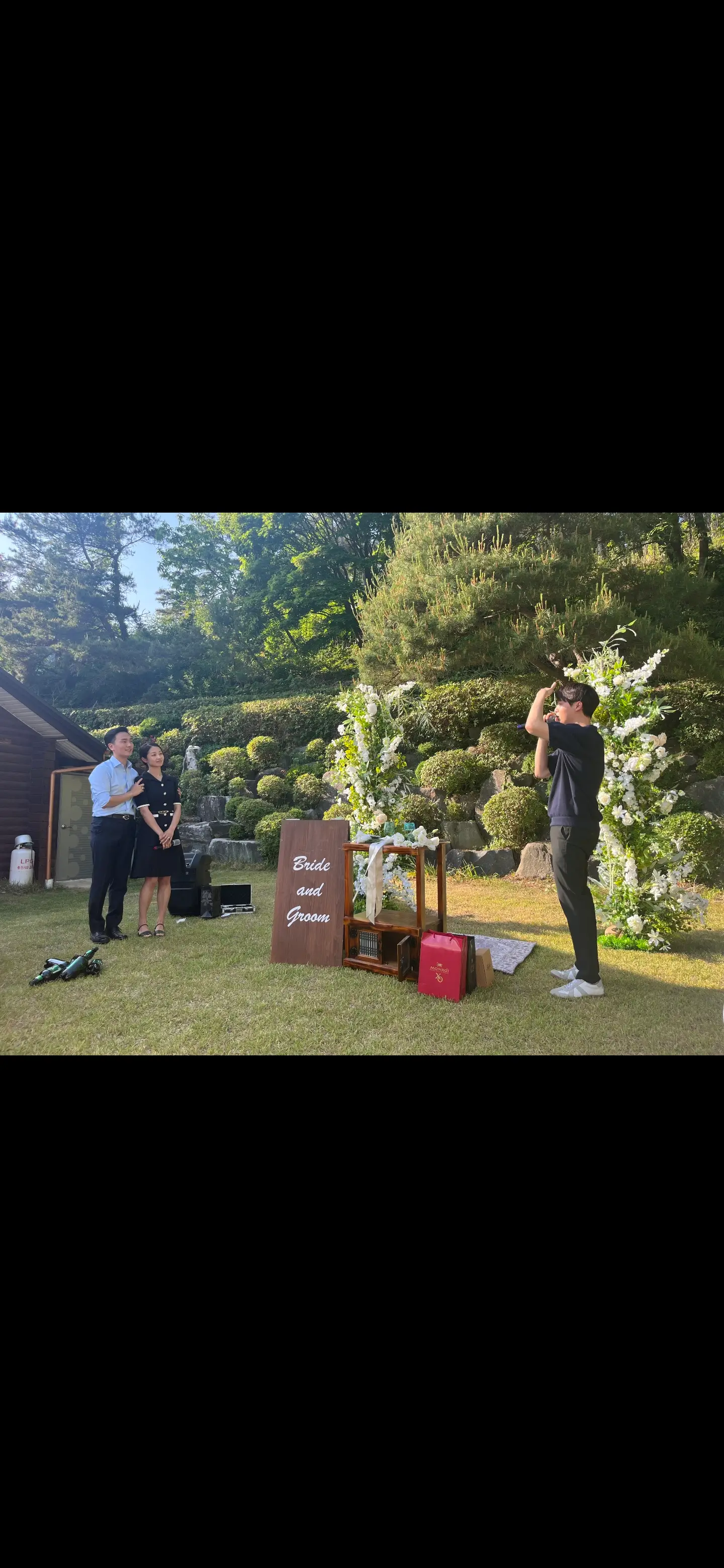 야외 가든 웨딩 잔디밭에서 신랑 신부를 마주 보며 축가를 부르는 남자 축가 가수 오창현